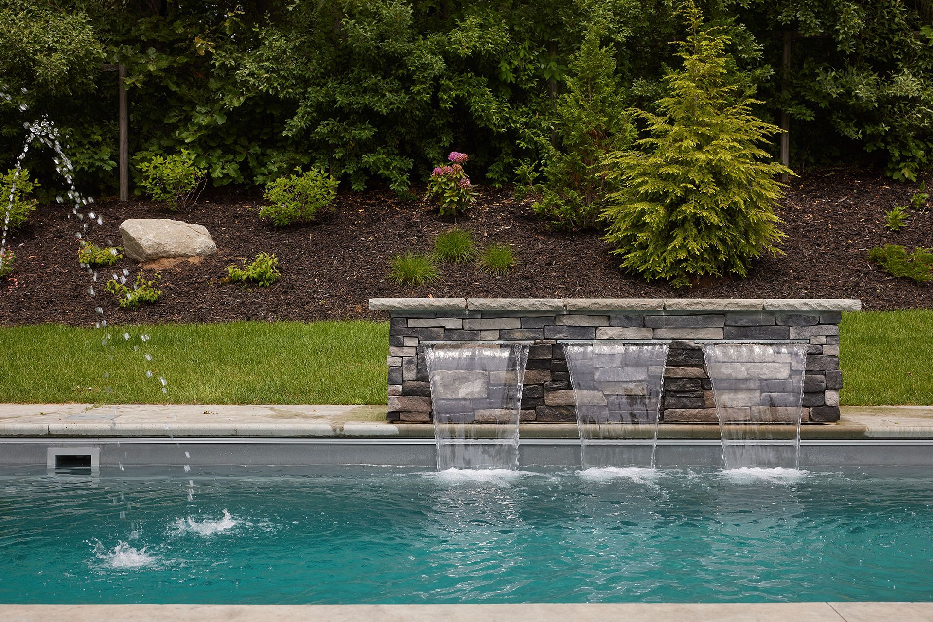 A swimming pool with a waterfall in the middle of it.