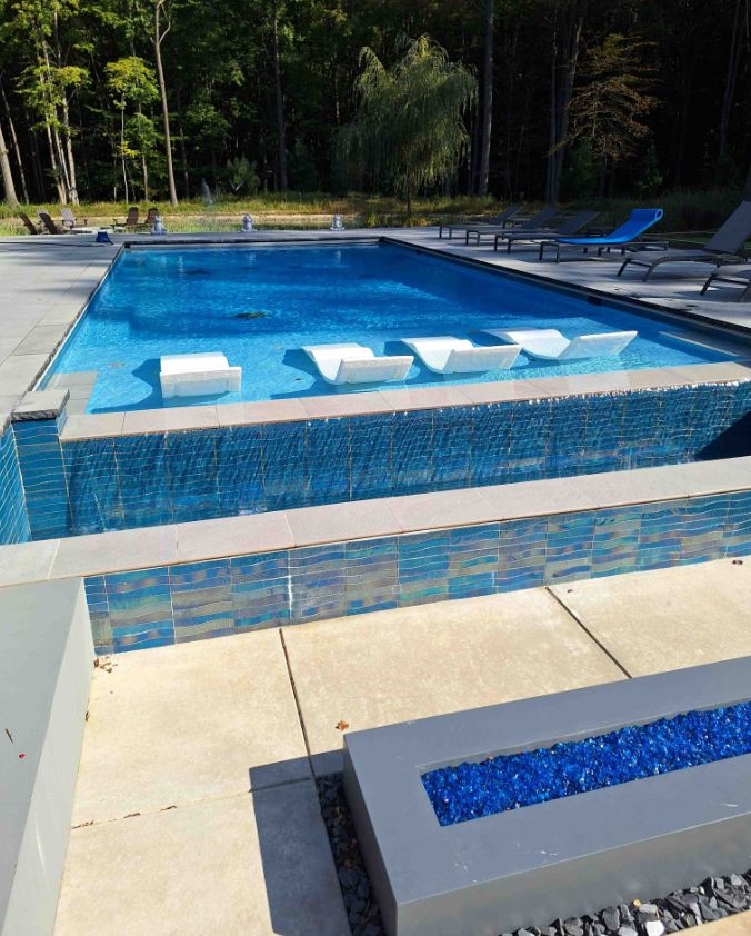 A large swimming pool with a fire pit in the middle