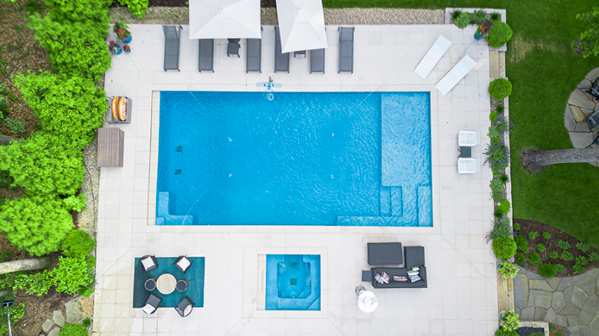 An aerial view of a large swimming pool surrounded by chairs and umbrellas.