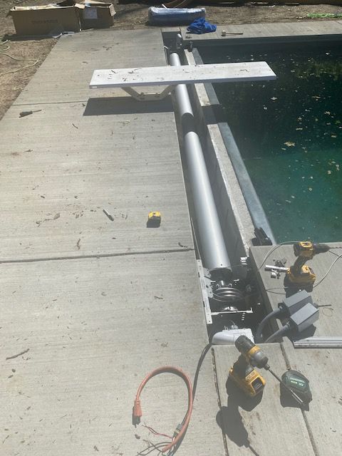 A swimming pool is being built next to a concrete deck.