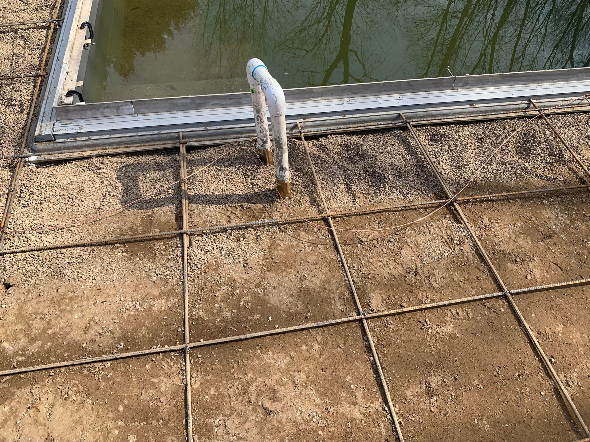 A dirty tiled floor next to a swimming pool.