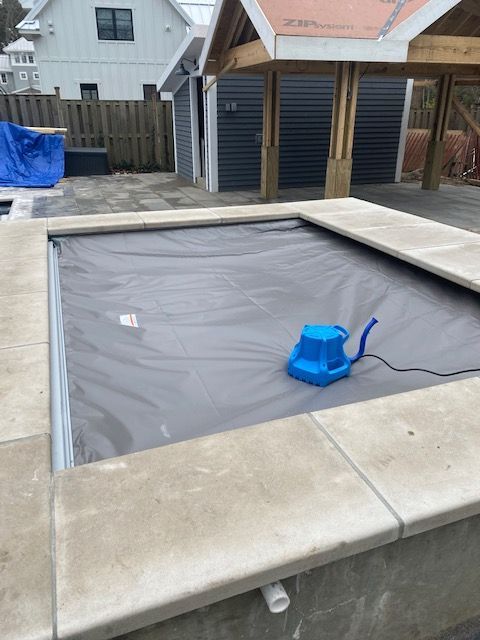 A blue water pump is sitting on top of a swimming pool.