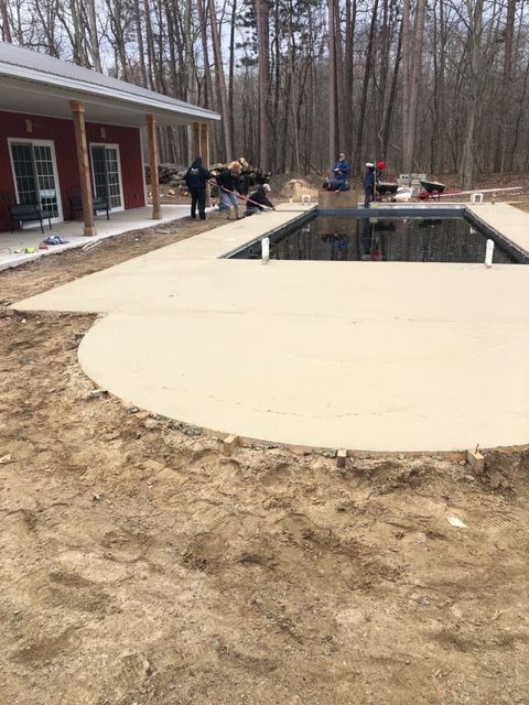 A swimming pool is being built in the backyard of a house.