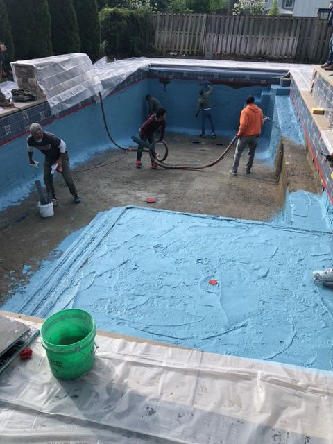 A group of people are working on a swimming pool.