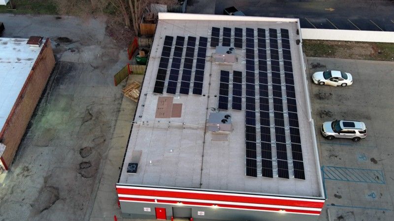 An aerial view of a building with solar panels on the roof.