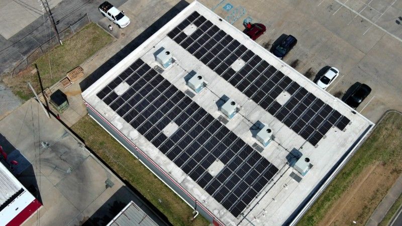 An aerial view of a building with solar panels on the roof.
