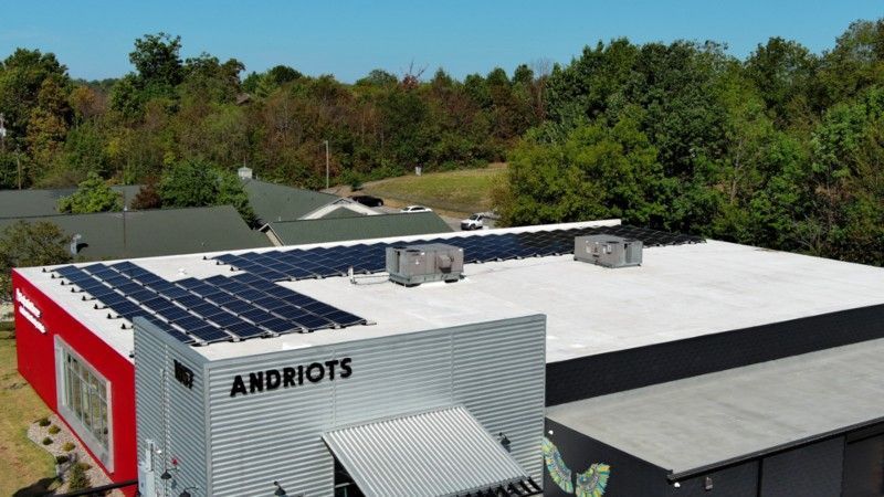 An aerial view of a building with solar panels on the roof.