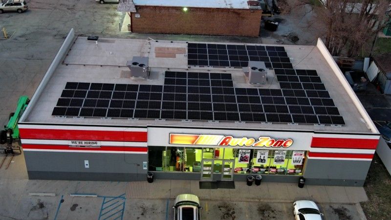 An aerial view of a convenience store with solar panels on the roof