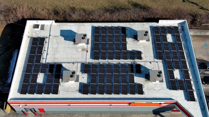 An aerial view of a building with solar panels on the roof