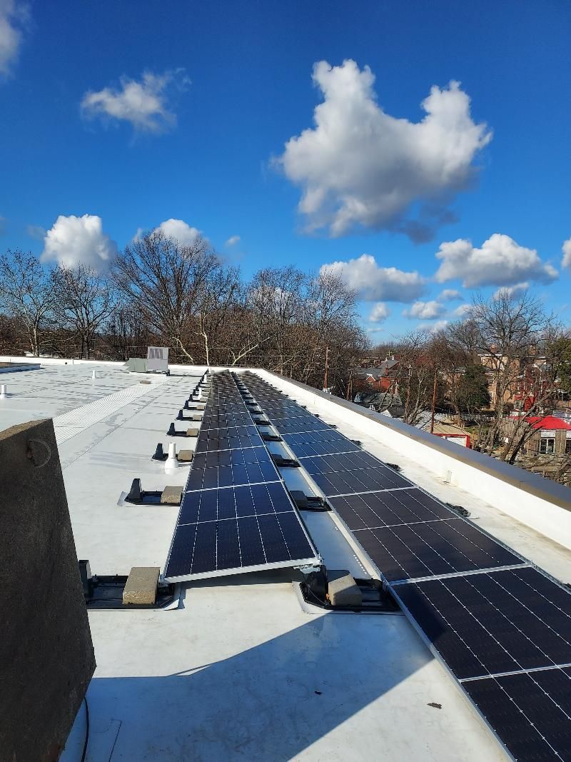 A row of solar panels on the roof of a building.