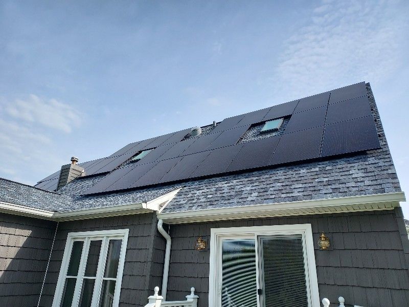 A house with solar panels on the roof and a skylight.
