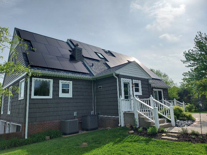 The back of a house with solar panels on the roof.