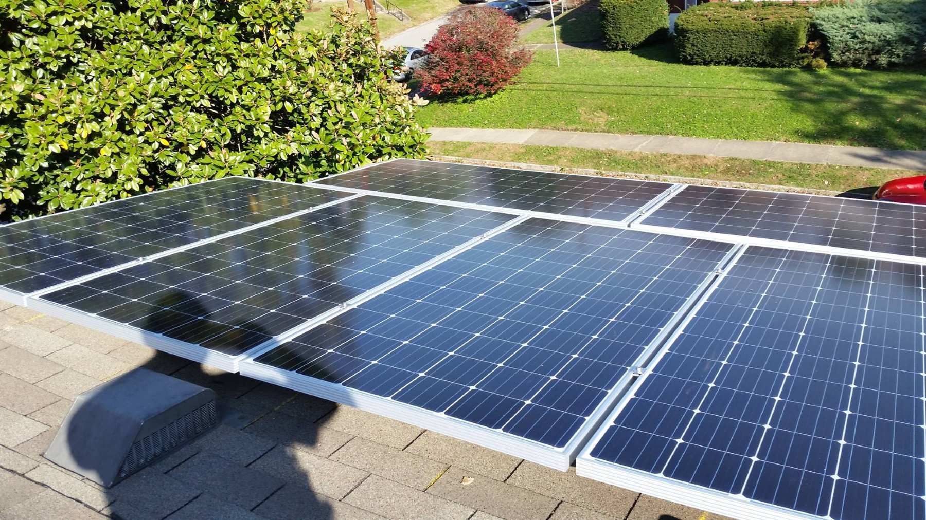 A row of solar panels are sitting on top of a roof.