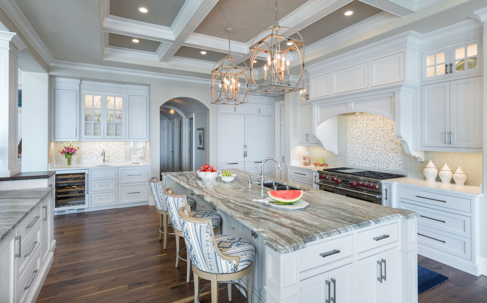 A kitchen with white cabinets , granite counter tops , and a large island.