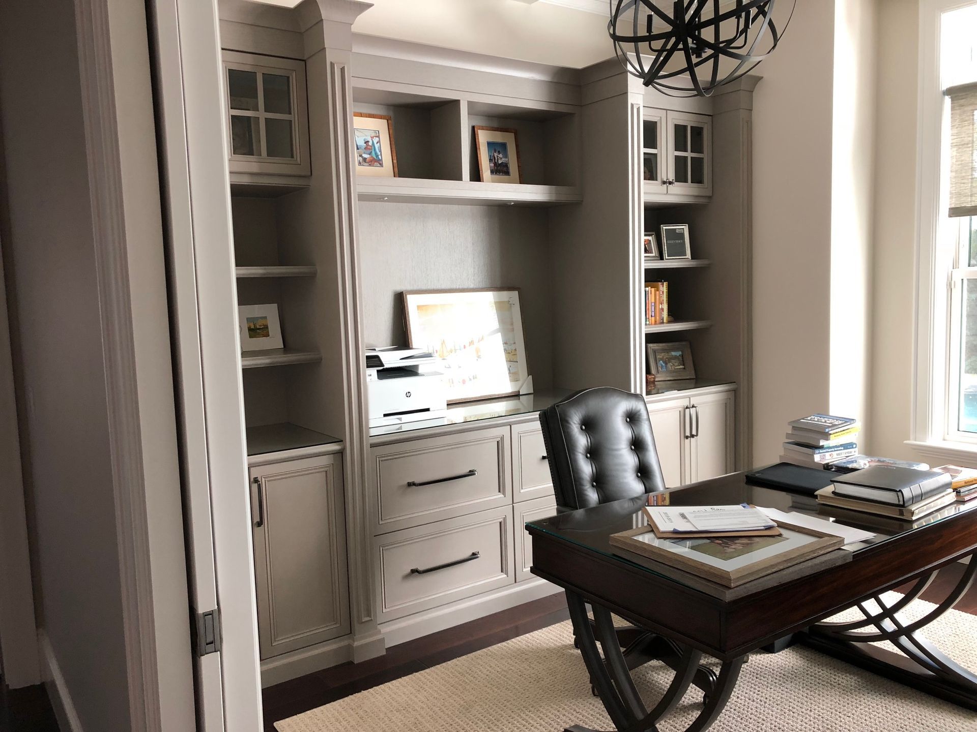 A home office with a desk , chair and shelves.