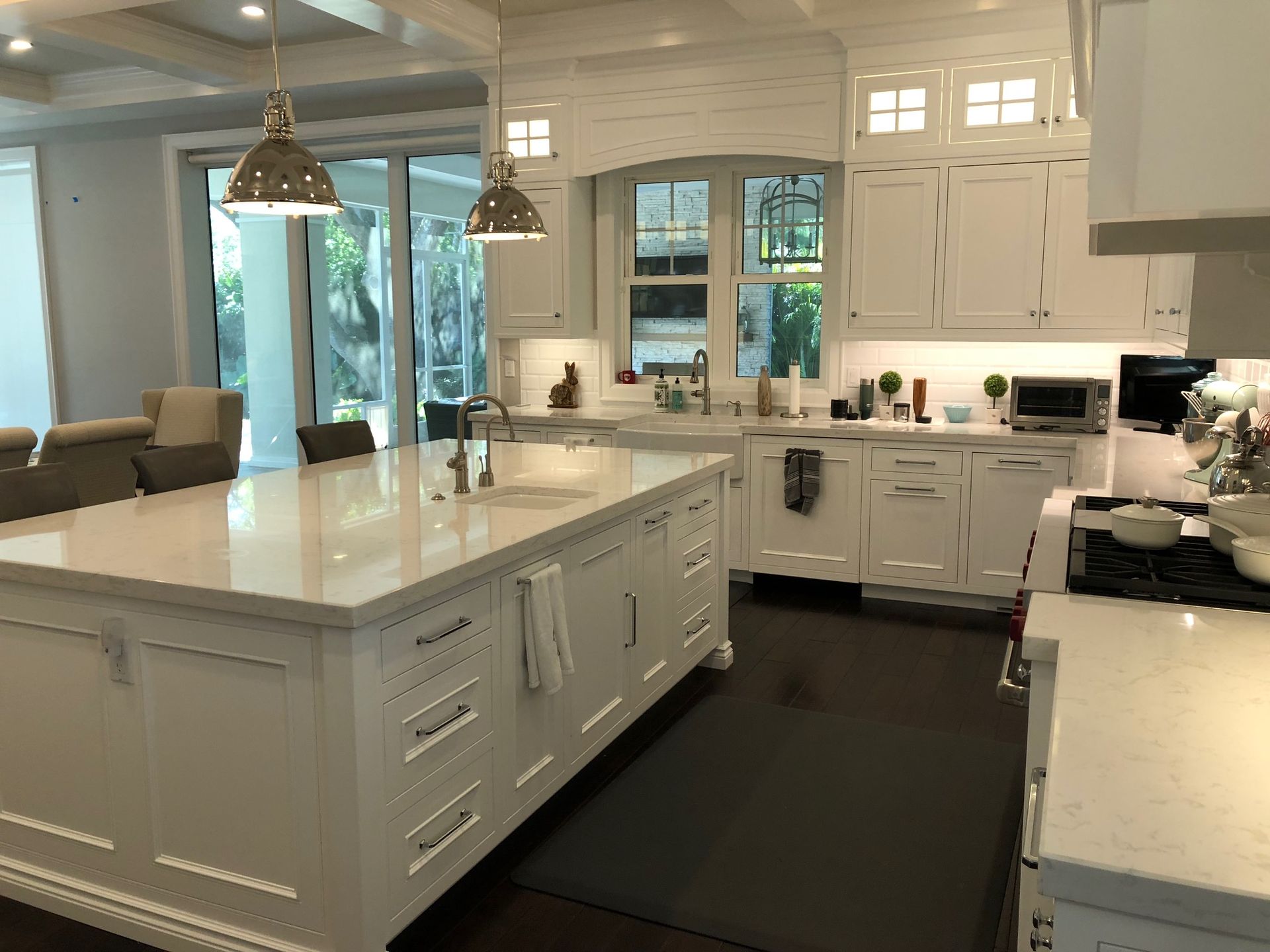 A kitchen with white cabinets and a large island in the middle.
