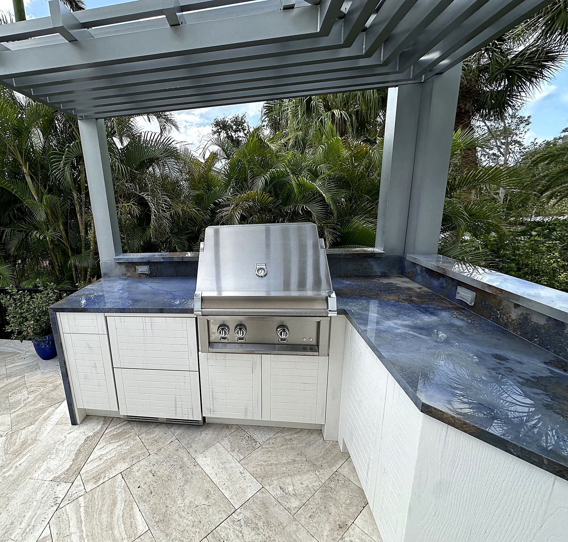 Outdoor kitchen run with the grill under the pergola