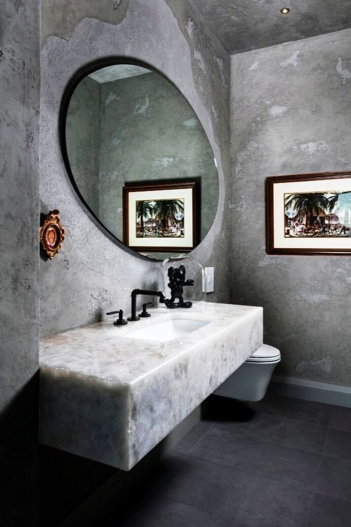 a bathroom with a sink and a round mirror