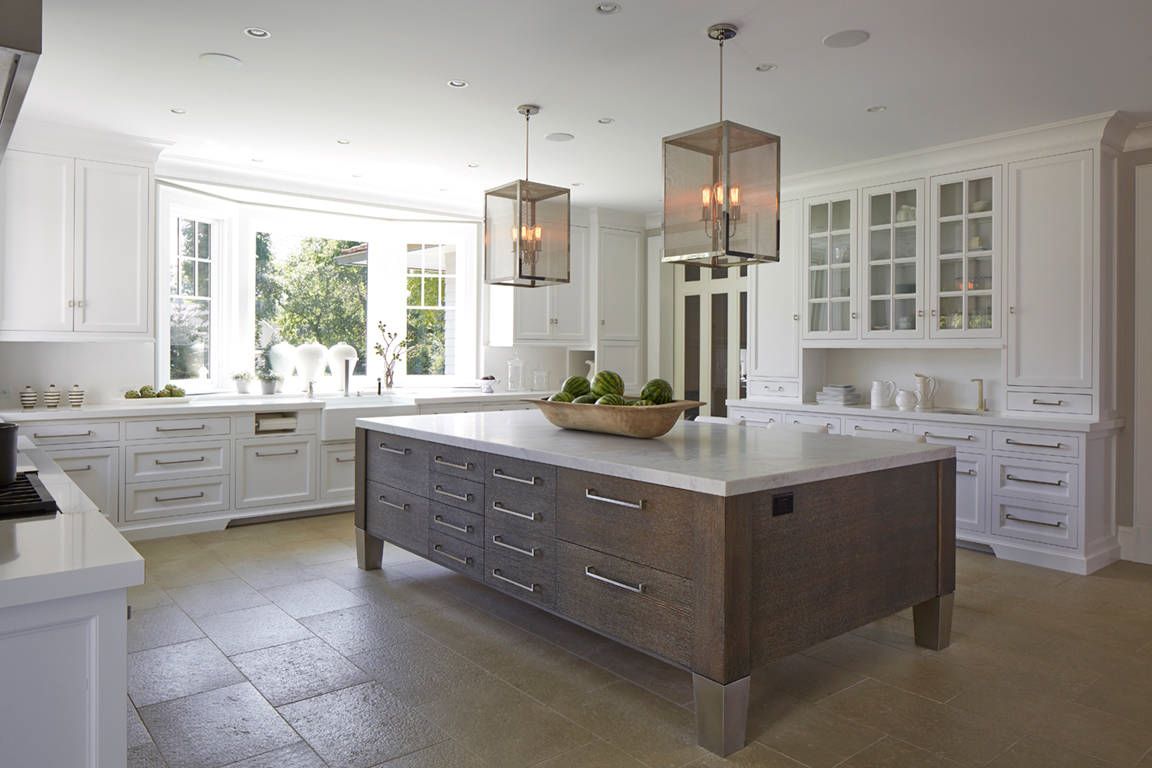 a kitchen with white cabinets and a large island in the middle