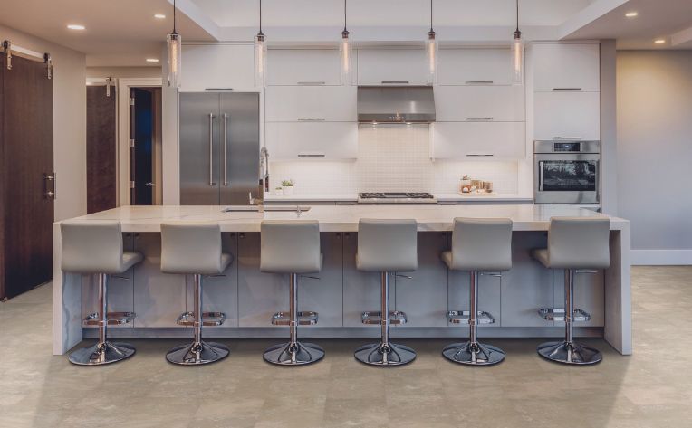 a kitchen with a large island and stools .
