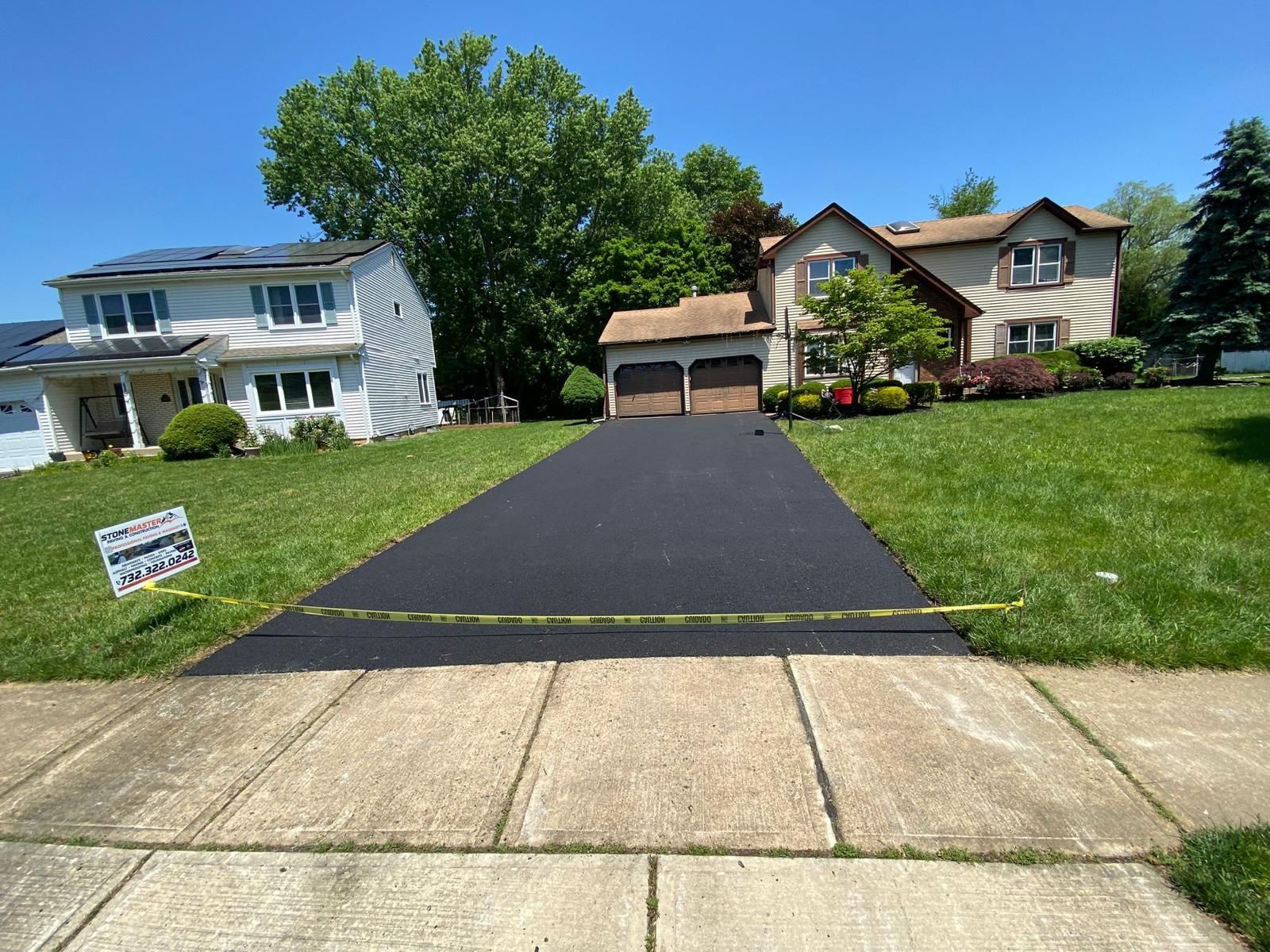 A driveway leading to a house in a residential neighborhood.