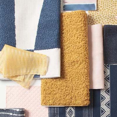 Close-up of fabric swatches in various textures and colors: blue, yellow, pink, and patterned textiles.