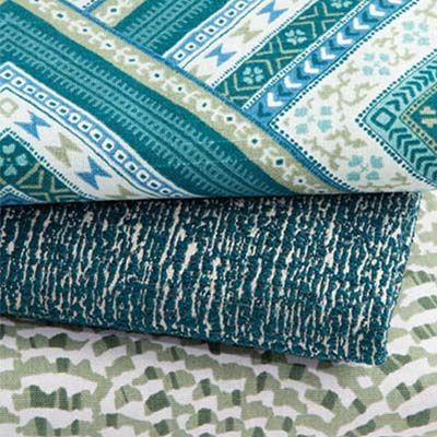 Folded fabric swatches with teal and white geometric patterns.