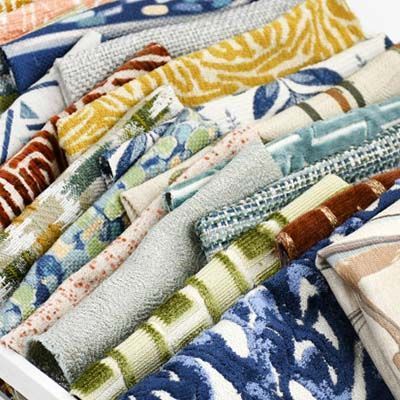 Close-up of a container with various colorful fabric swatches, showing different textures and patterns.