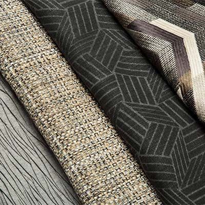 Close-up of several fabric swatches in various patterns and textures; neutral colors.