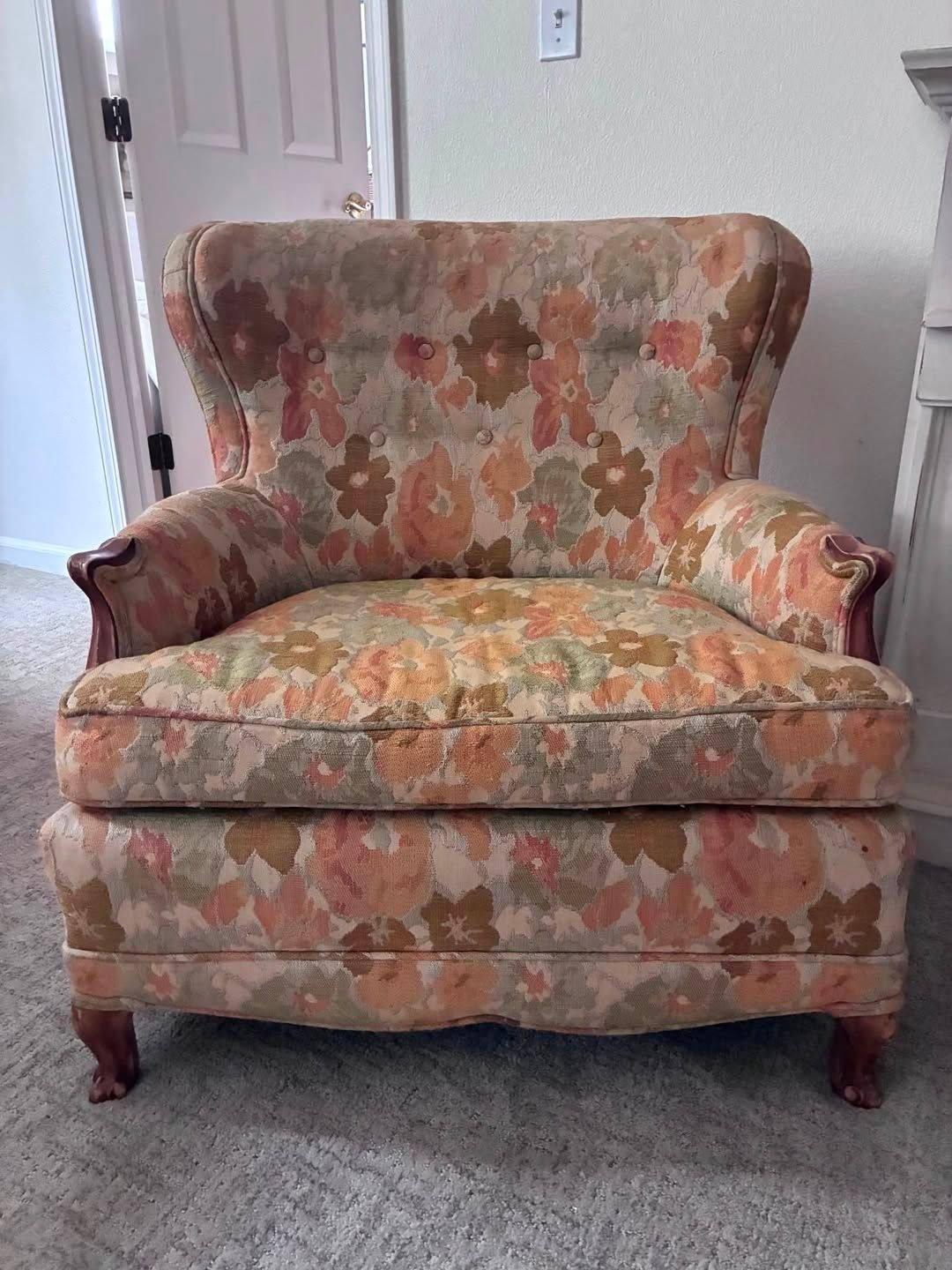 Floral upholstered armchair with matching ottoman in a carpeted room