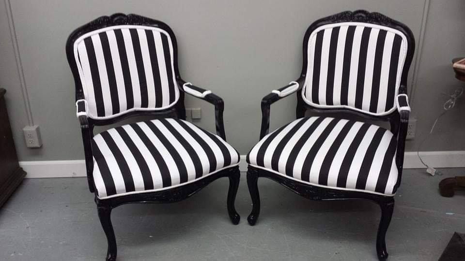 Two black and white striped armchairs against a gray wall.