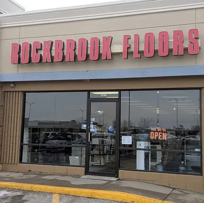 Rockbrook Floors store front with red sign, glass windows, and door.