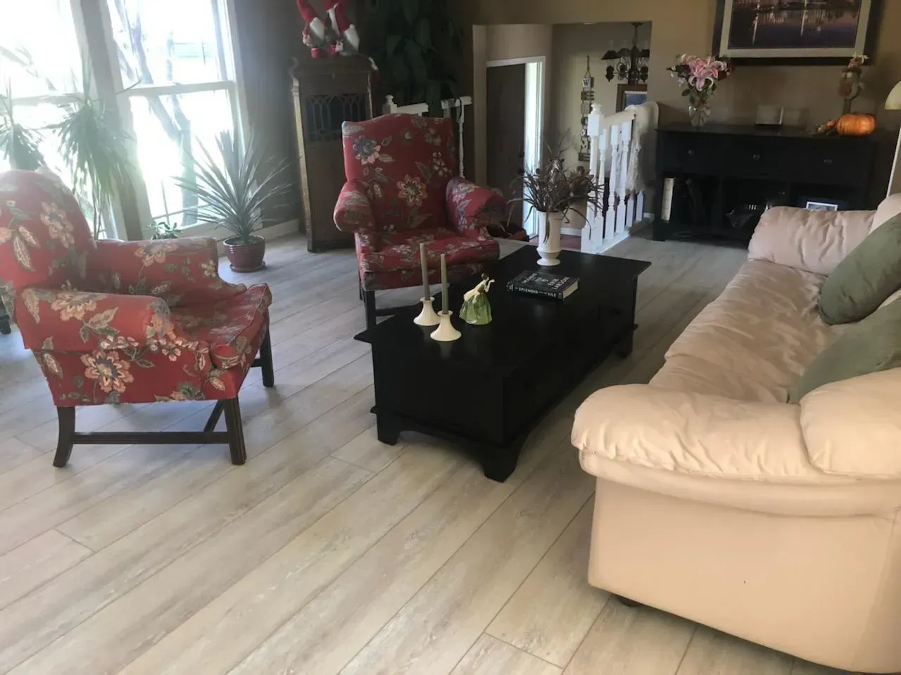 Living room with floral armchairs, a black coffee table, and a light pink sofa.