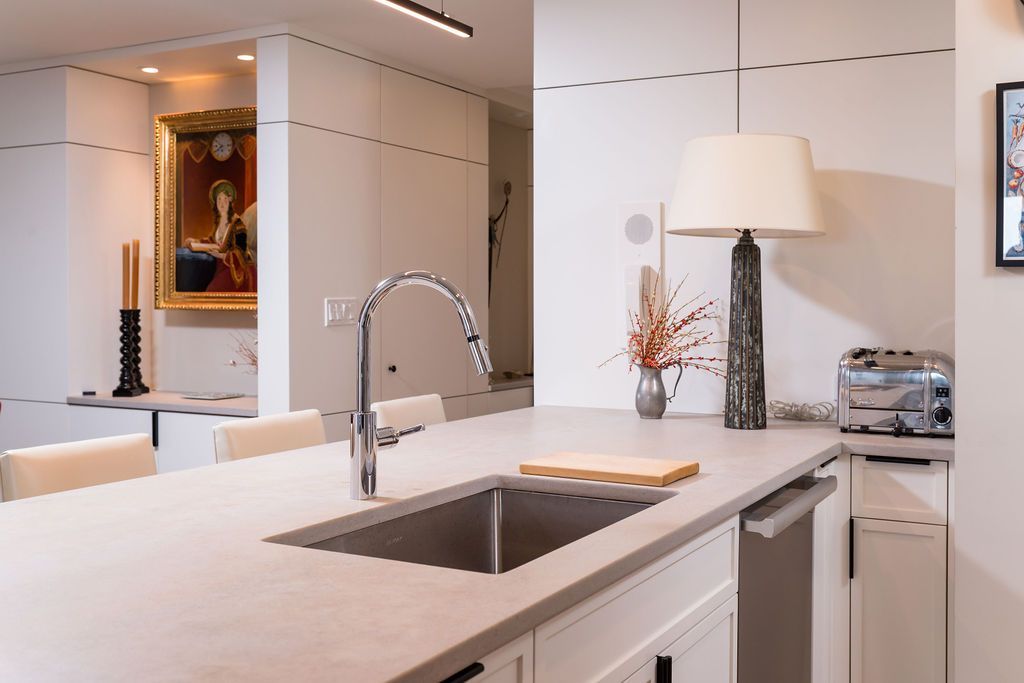 Bright modern kitchen with white island, chrome faucet, and countertop decor