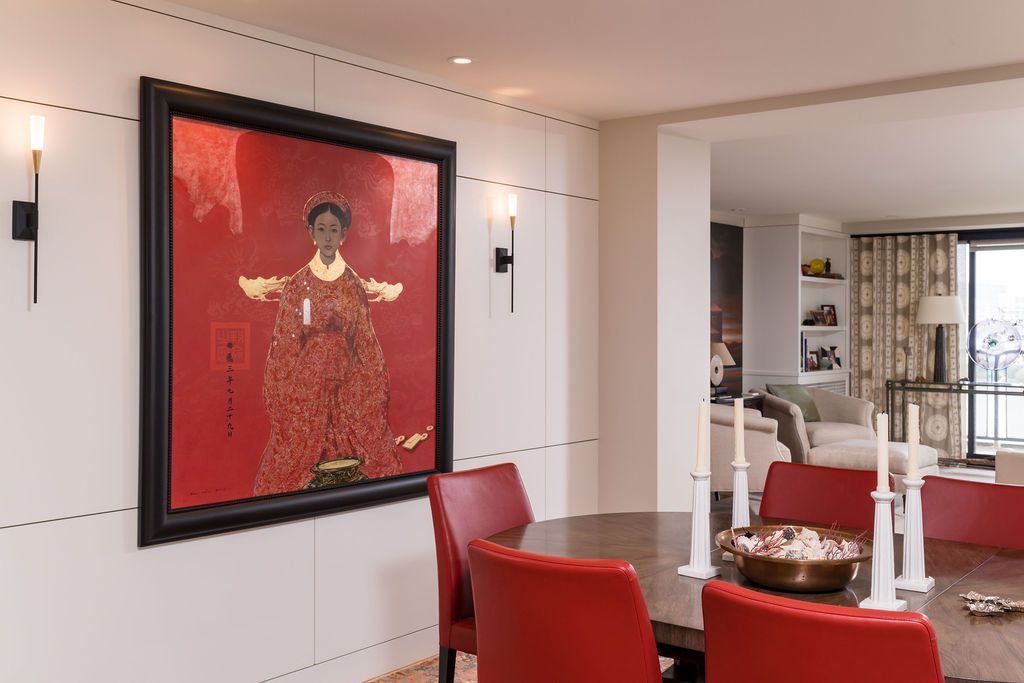 Modern living room with red chairs, a fireplace, and a large red-toned framed artwork on the wall