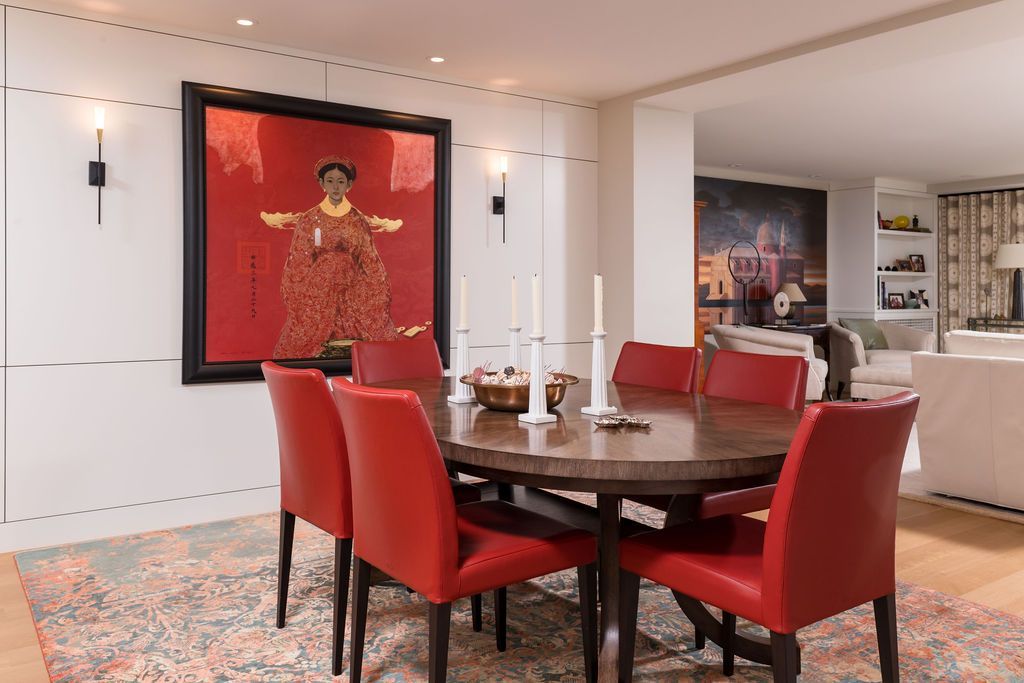 Modern dining room with red chairs, dark wood table, and red wall art on the far wall