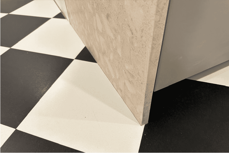 Abstract geometric sculpture on a black-and-white checkerboard floor, with beige angled panels.