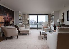 Modern living room with beige seating, large wall art, and sliding doors to a balcony.