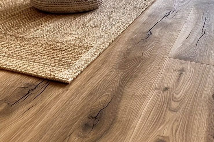 Wooden floor with a woven rug corner and a basket in the background