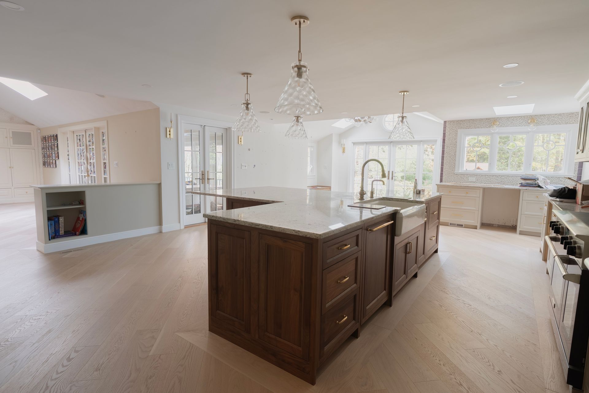 Bright open kitchen with large island, white cabinets, and pendant lights in a modern home