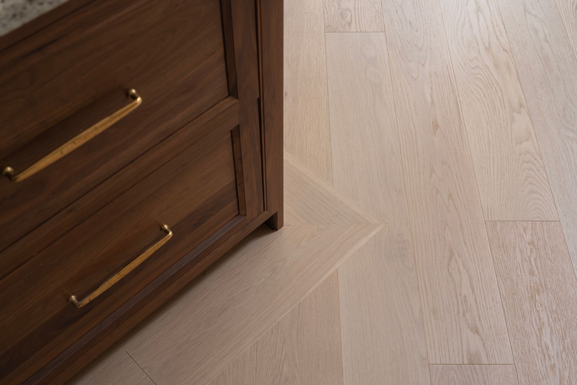 Wooden dresser with brass handles on a light hardwood floor