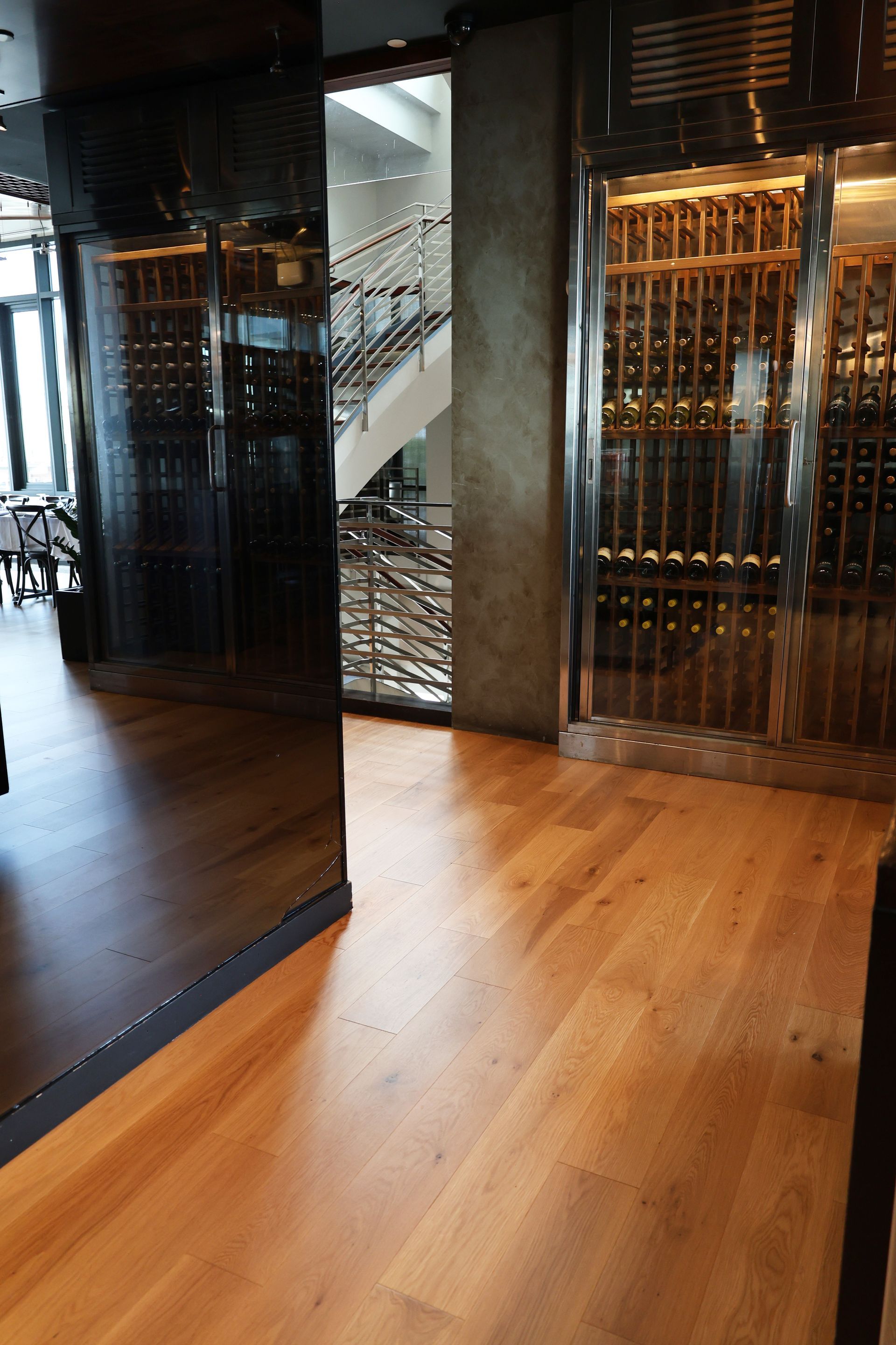 Modern lobby with wood flooring, mirrored wall, and gold elevator doors