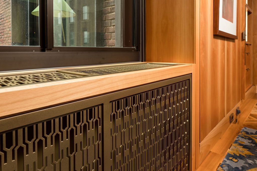 Wood-paneled hallway with window, radiator cover, and patterned carpet