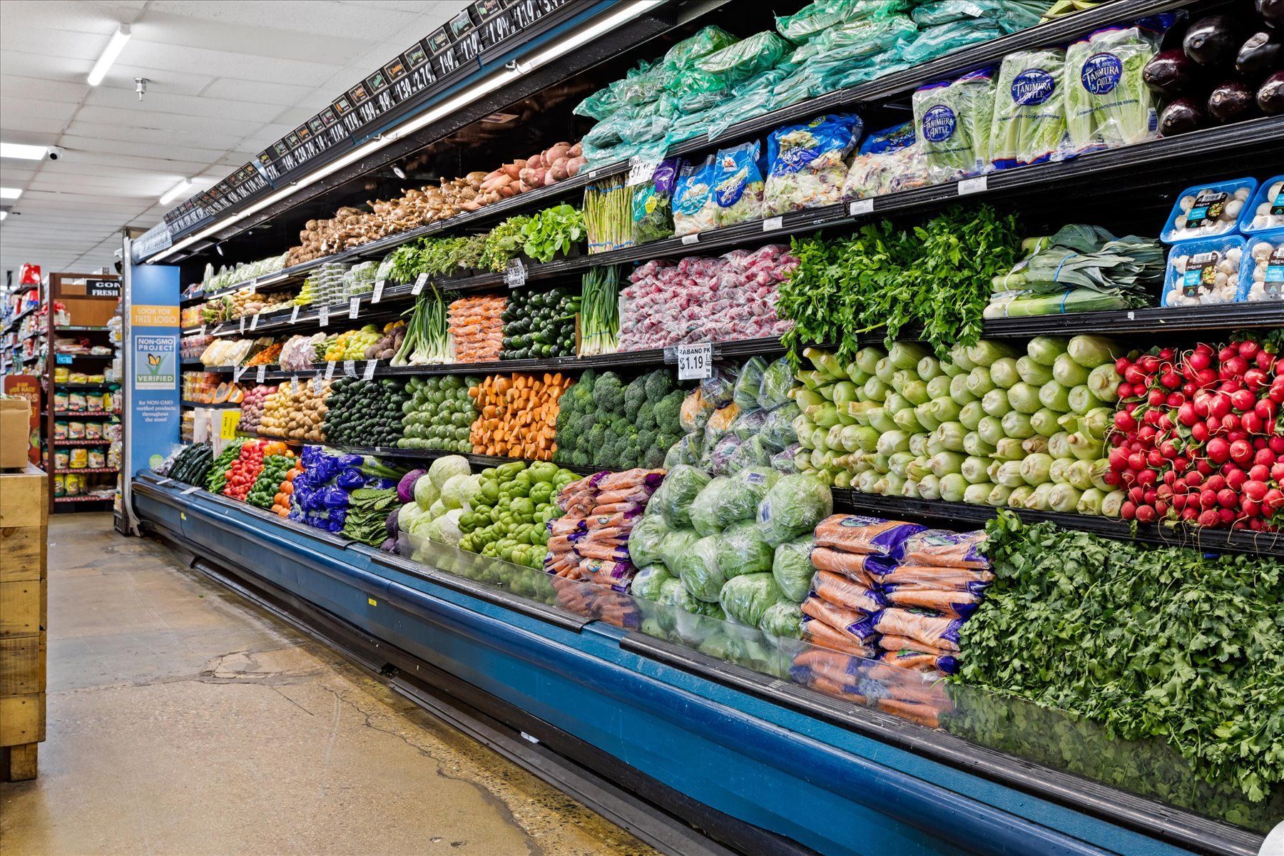 A grocery store aisle filled with lots of fruits and vegetables.