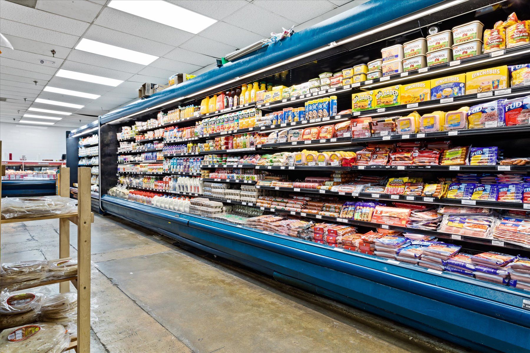 A grocery store aisle filled with lots of food.