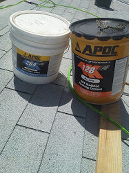 Two APOC plastic roof cement