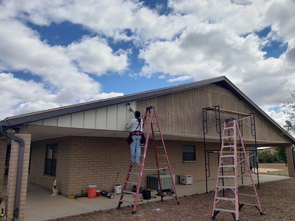 Man painting the siding of a building