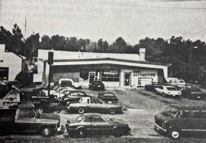 Reception area with desk, computers, and door to auto shop.
