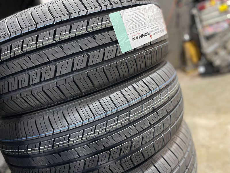 Three stacked black tires with tread patterns and a label.