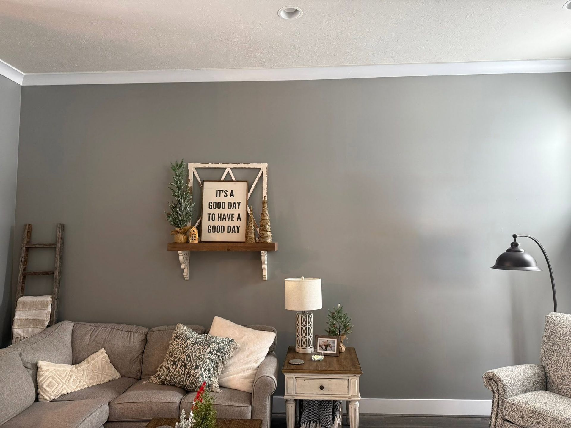 Cozy living room with gray walls, a couch, lamp, floor lamp, and framed wall decor